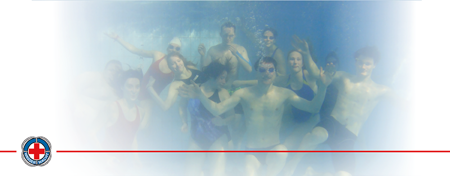 Eine Gruppe von Ehrenamtlichen der Wasserwacht tauchen in einem großen Pool, stehen am Boden und posieren für die Kamera.