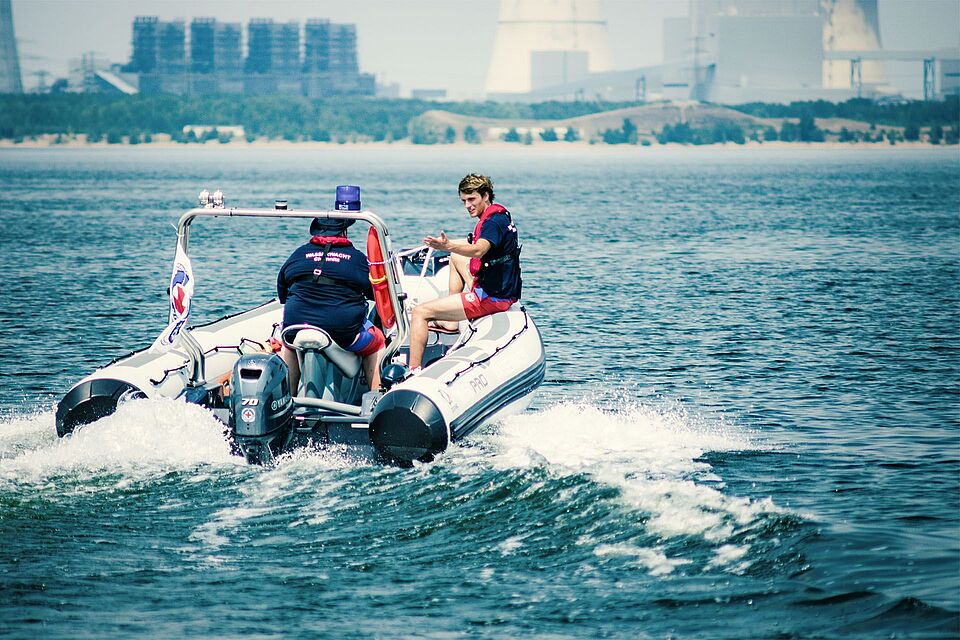 Mitglieder der Wasserwacht fahren mit einem Rettungsboot den See hinaus